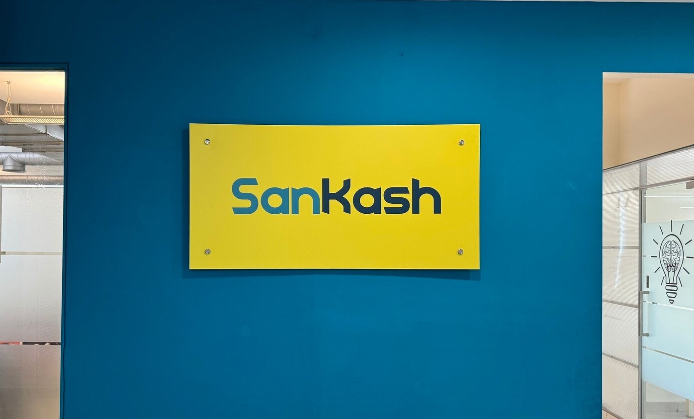 Bright yellow SanKash sign on wall