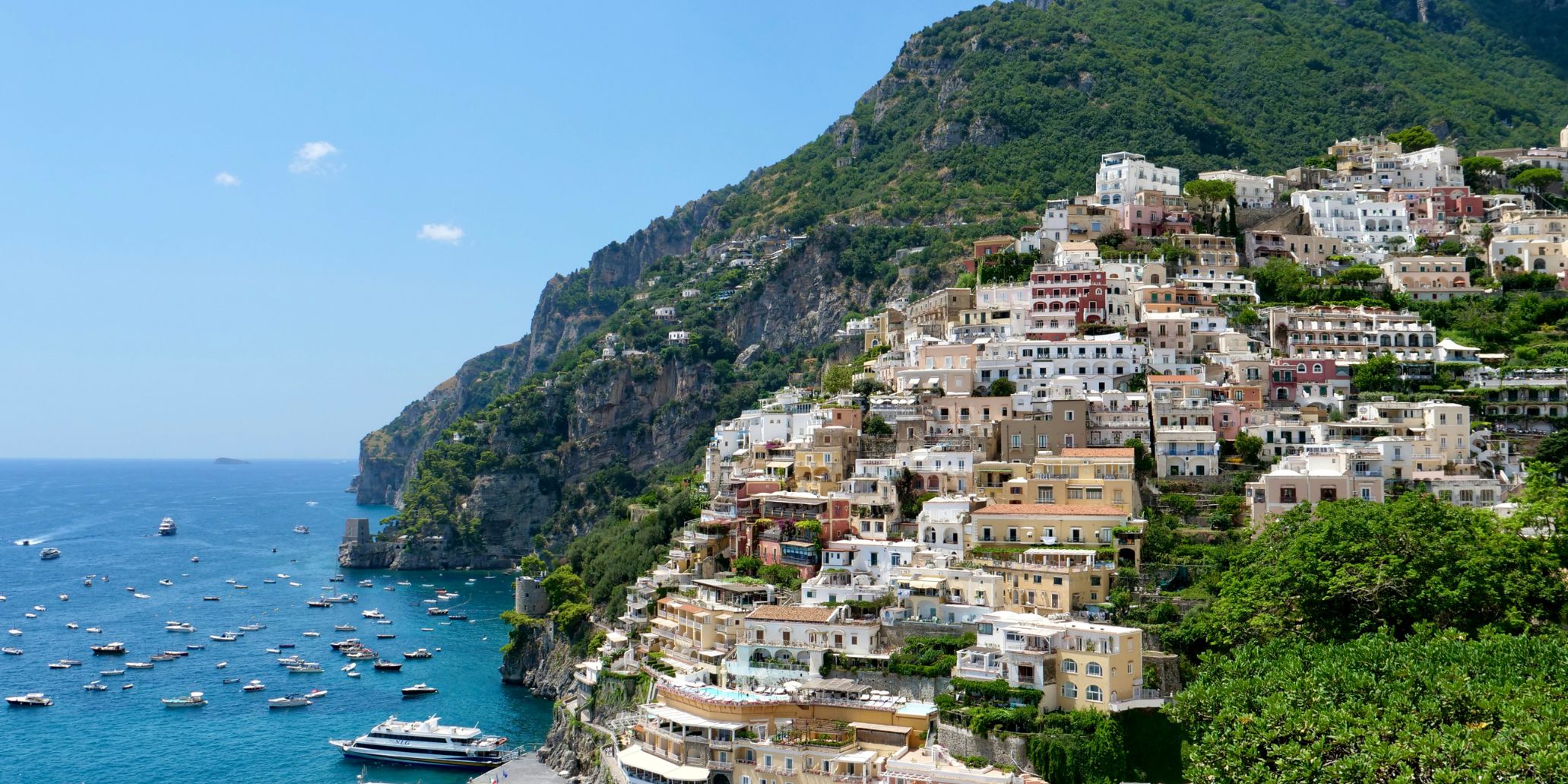 Positano romantic sunset view with colorful houses and boats.